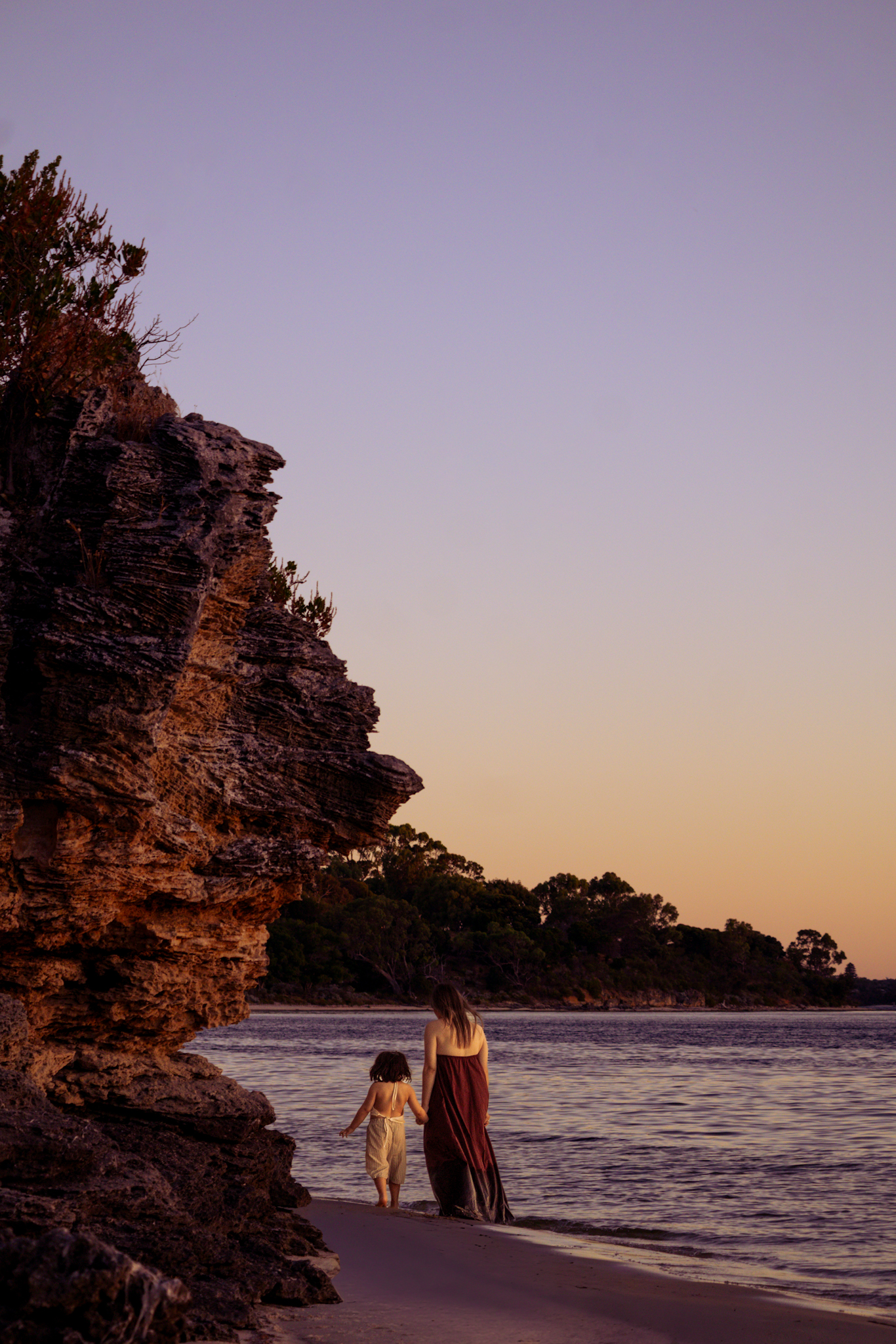 Candid photo of mum and little girl walking away in the distance by the Swan River